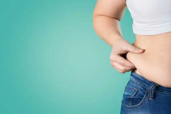Image of woman pinching her love handles to show weight gain Alton